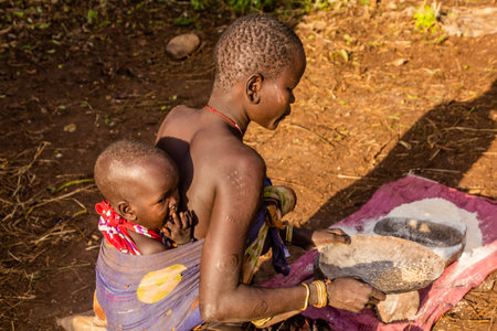 OMO VALLEY, ETHIOPIA - FEBRUARY 6, 2020: Mursi tribe girl in her village, Ethiopia