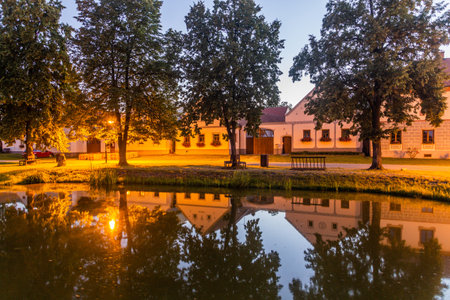 Pond and traditional houses of rural baroque style in Holasovice village, Czech Republicの写真素材