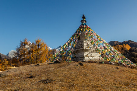 Stupa with prayer flags in Haizi valley near Siguniang mountain in Sichuan province, China