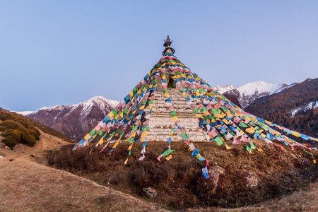 Stupa with prayer flags in Haizi valley near Siguniang mountain in Sichuan province, Chinaの写真素材