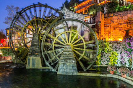 LIJIANG, CHINA  - NOVEMBER 8, 2019: Evening view of water wheels in the old town of Lijiang, Yunnan province, Chinaのeditorial素材