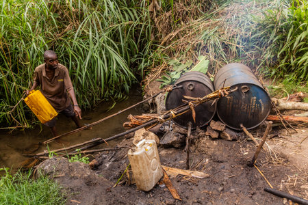 KIBUGA, UGANDA - MARCH 13, 2020: Rural banana alcohol distillery near Kibuga village in the crater lakes region near Fort Portal, Ugandaのeditorial素材