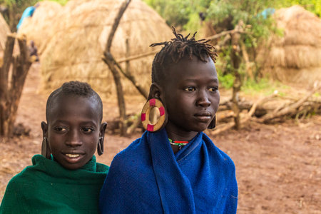 OMO VALLEY, ETHIOPIA - FEBRUARY 6, 2020: Young girls, members of Mursi tribe, Ethiopia