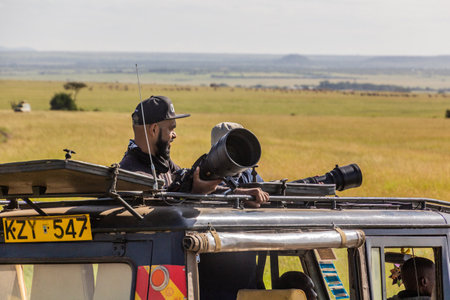 MASAI MARA, KENYA - FEBRUARY 19, 2020: Photographers in a safari vehicle in Masai Mara National Reserve, Kenyaのeditorial素材