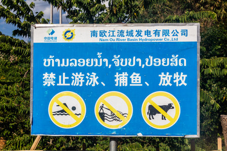 NAM OU, LAOS - NOVEMBER 23, 2019: Sign now swimming, no fishing, no cattle at the Nam Ou 5 dam, Laos