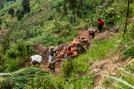 MOUNT ELGON, UGANDA - FEBRUARY 26, 2020: Local people on a rural trail near Mount Elgon, Ugandaのeditorial素材
