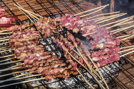 Skewers being grilled at a street food stall in Ugandaの写真素材