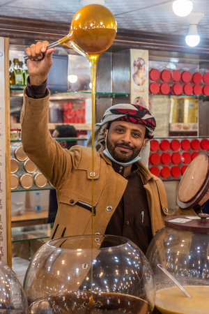ABHA, SAUDI ARABIA - NOVEMBER 19, 2021: Honey seller at Thulathaa Traditional Market in Abha, Saudi Arabiaのeditorial素材