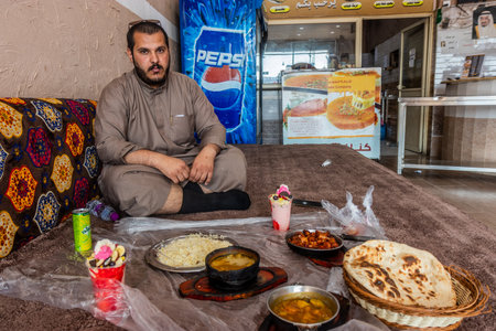 DHAHRAN AL JANUB, SAUDI ARABIA - NOVEMBER 25, 2021: Local man having a lunch in a restaurant in Dhahran al Janub, Saudi Arabiaのeditorial素材