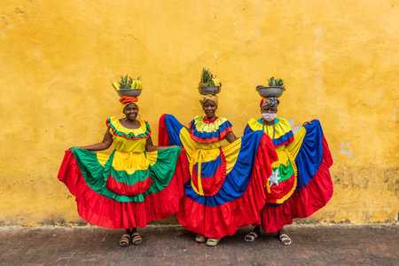 CARTAGENA DE INDIAS, COLOMBIA - MARCH 6, 2023: Palenquera women wearing traditional costume sell fruits in the center of Cartagena.のeditorial素材