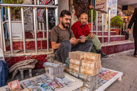 SORAN, IRAQ - OCTOBER 3, 2022: Street money changer in Soran city with stacks of bills, Kurdistan...