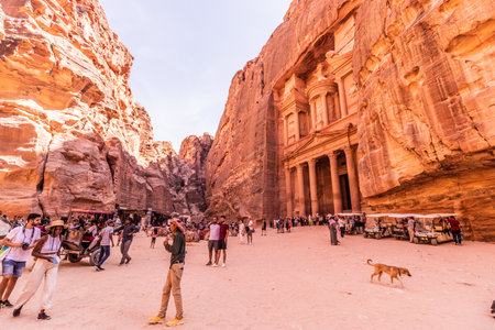 PETRA, JORDAN - JULY 11, 2022: Tourists in front of the Al Khazneh temple (The Treasury) in the...