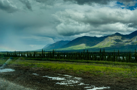 Rainbow with street in Alaska United States of Americaの写真素材
