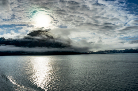 Mountains covered in clouds on a misty morning on the Ferry towaの写真素材