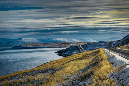 Empty Street with Icelandic Landscape during Sunrise Golden Hourの写真素材