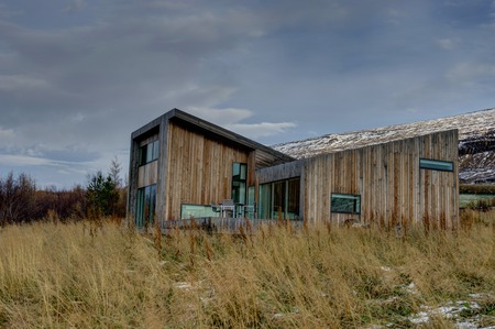 Villa Lolla House near Akureyri with yellow grass and cloudy skyのeditorial素材