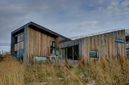 Villa Lolla House near Akureyri with yellow grass and cloudy skyのeditorial素材