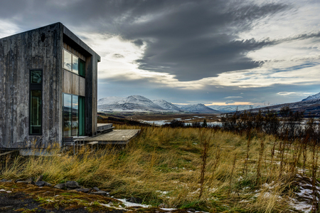Villa Lolla House near Akureyri with yellow grass and cloudy skyのeditorial素材