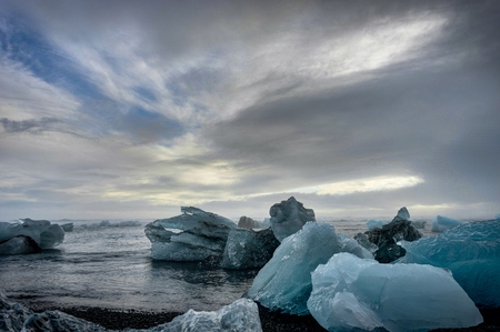 Icebergs floating in Jokulsarlon glacier lake at sunset in Icela