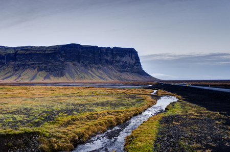 Icelandic Landscape with mountains and river with grass and streの写真素材