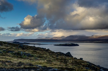 Iceland view over water towards mountains with blue sky and clouの写真素材
