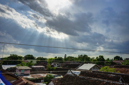 Sunrays in with clouds and sky and houses in jogjakarta Indonesiの写真素材