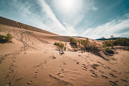 Sand dunes under blue sky. Sahara Desert, Previously, village houses transferred due to sands movement.の写真素材
