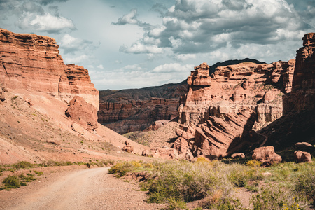 Charyn Grand Canyon with clouds and sun red orange stone Martian landscapeの写真素材