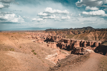 Charyn Grand Canyon with clouds and sun red orange stone Martian landscapeの写真素材