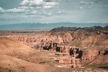 Charyn Grand Canyon with clouds and sun red orange stone Martian landscapeの写真素材