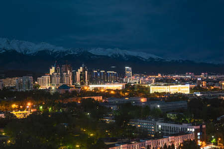 City landscape on a background of snow-capped Tian Shan mountains in Almaty Kazakhstanの写真素材
