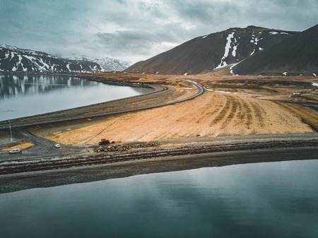 Aerial view of road 1 in iceland with bridge over the sea in Snaefellsnes peninsula with clouds, water and mountain in backgroundの写真素材