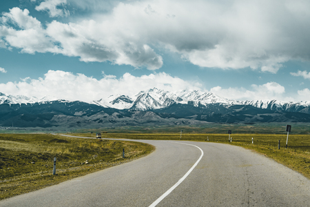 Street in steppe with Tian Shan mountains in background, Kazakhstan Central Asiaの写真素材