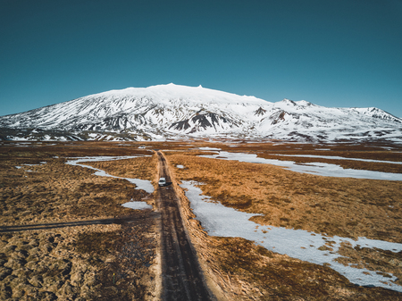 Aerial drone photo of a empty quit road road towards a huge volcanic mountain Snaefellsjokull in the distance, near Snaefellsjokull national park, Iceland.の写真素材