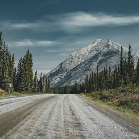View of street highway with mountains and trees with blue sky and clouds. Banff National Park Canada Rocky Mountains.の写真素材