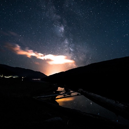 Milky Way galaxy night sky over small pond with reflection. Canada, British Columbia.