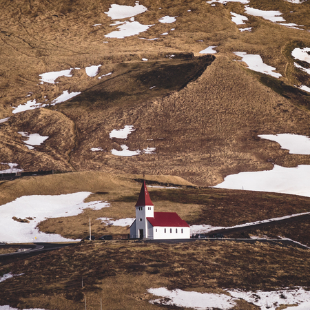 Panoramic view of the Vik at sunrise sunset . South Iceland.Typical red colored wooden church in Vik town, Iceland in winter.の写真素材