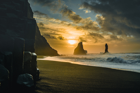 The black sand beach of Reynisfjara and the mount Reynisfjall, Iceland. Windy Morning. Ocean Waves. Colorful Sky. Morning Sunset.の写真素材