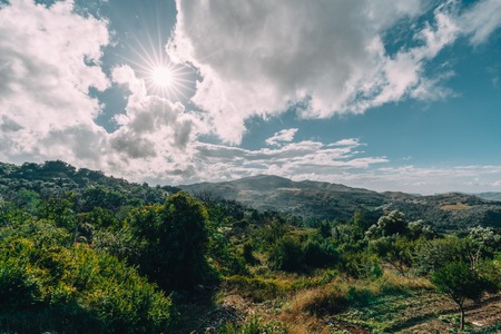 Crete Greece, View on mountains with low hanging clouds and blue sky and green trees. South Crete neat Rethymno, Greeceの写真素材
