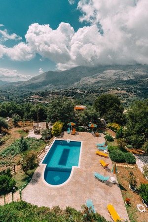 Mesonisia, Rethymno, Crete - August 2018: View towards swimming pool of villa Krios on a sunny day with blue sky. Krios Villa is a resort located in Mesonisia village in Rethymno,Crete.のeditorial素材