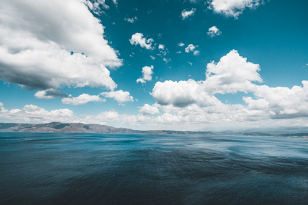 Panoramic view of rocks and beach with sky and clouds in Crete, Greece. Amazing scenery with crystal clear water and the rock formation against a deep blue sky during Summer period. Greece, Europeの写真素材