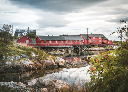 September 2018, Henningsvaer Lofoten island. Red Rorbuer houses in the Henningsvaer fishing village on a cloudy day. The small fishing village Henningsvaer is located in the Lofoten archipelago.のeditorial素材