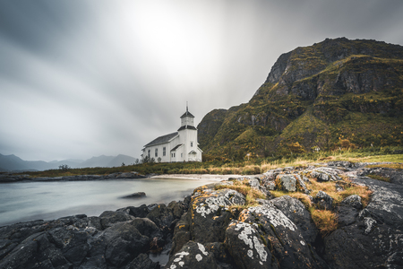 Long exposure of the white church of Gimsoy with rocks and atlantic ocean. Photo taken on Gimsoy Island, Lofoten Norway.のeditorial素材