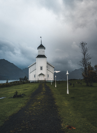 Long exposure of the white church of Gimsoy with rocks and atlantic ocean. Photo taken on Gimsoy Island, Lofoten Norway.のeditorial素材