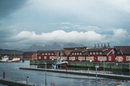 Svolvaer, Norway - September 2018: Boats in the waterfront harbor with mountains in the background. Svolvaer is a fishing village and tourist town located on Austvagoya in the Lofoten Islands.のeditorial素材
