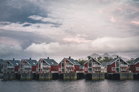 Svolvaer, Norway - September 2018: Red houses waterfront with sunset in the background. Svolvaer is a fishing village and tourist town located on Austvagoya in the Lofoten Islands.のeditorial素材