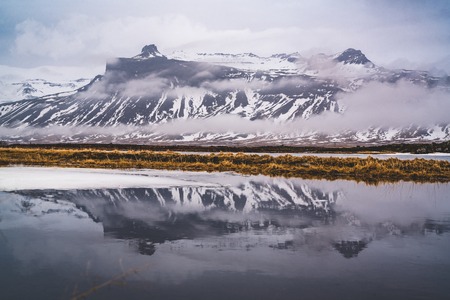 Reflection of a Mountain in Iceland on a north atlantic ocean bay.の写真素材