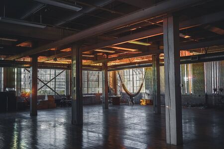 Detroit, Michigan, May 18, 2018: Inside view of abandoned Loft flat in Detroit. Windows show city life around the apartment.のeditorial素材