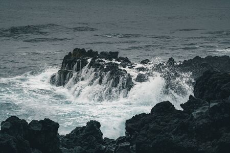 Azores, Big waves crashing over black volcanic rock on the Atlantic Ocean in the coast of Sao Miguel...