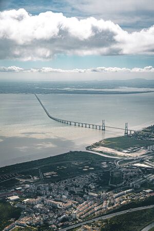 Aerial panorama view over the 25 de Abril Bridge. The bridge is connecting the city of Lisbon to the municipality of Almada on the left bank of the Tejo river, Lisbonのeditorial素材